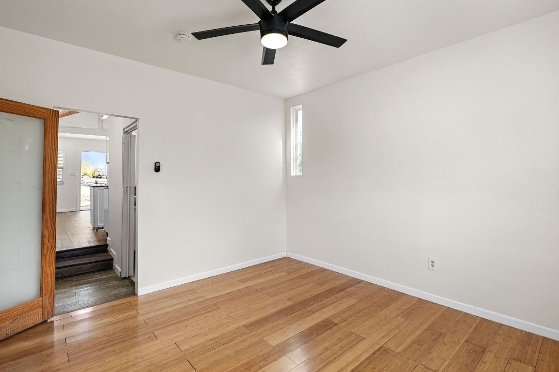 13415 Crane Road Buda, TX 78610 - Photo 9 of 22 Unfurnished room with hardwood / wood-style floors and a ceiling fan