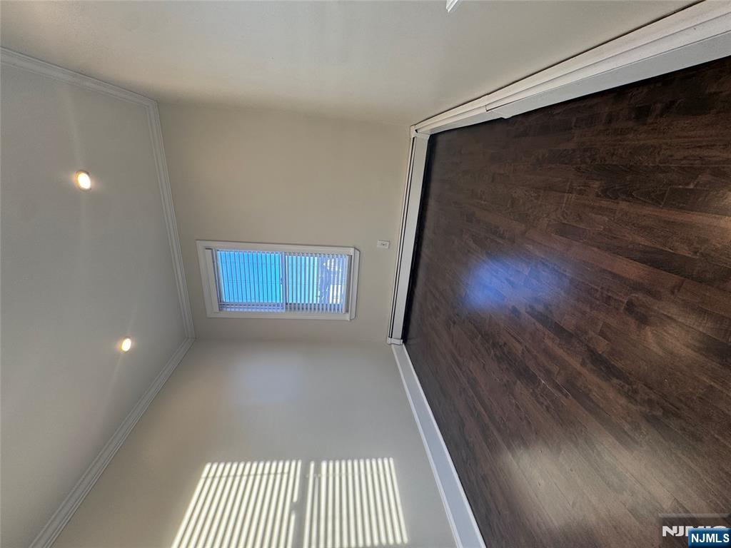 14 River Street Lodi, NJ 07644 - Photo 5 of 9 an empty room with wooden floor and windows