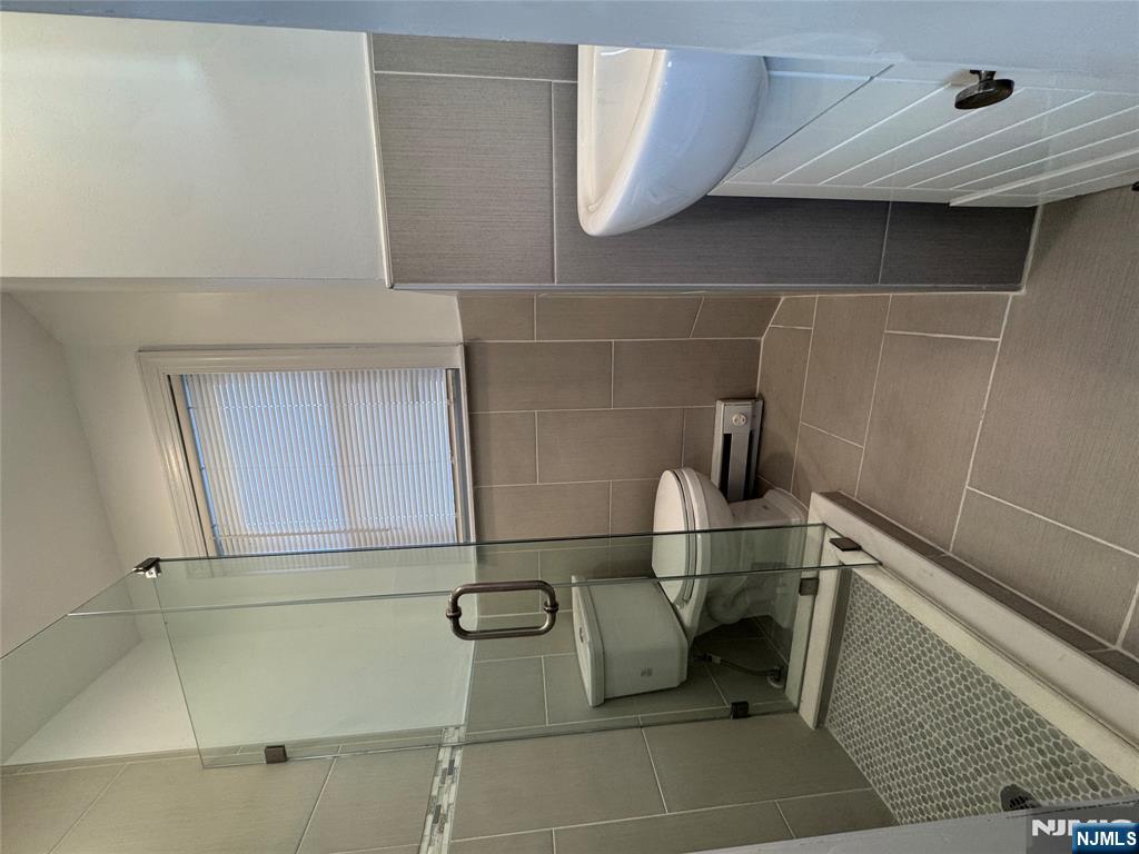 14 River Street Lodi, NJ 07644 - Photo 7 of 9 a bathroom with a sink a toilet and mirror