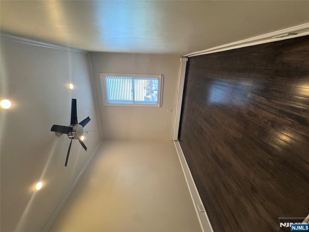 14 River Street Lodi, NJ 07644 - Photo 8 of 9 an empty room with wooden floor fan and windows