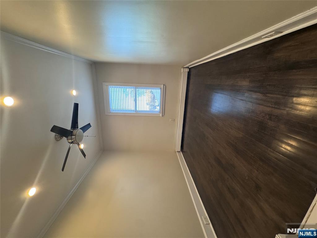 14 River Street Lodi, NJ 07644 - Photo 9 of 9 an empty room with wooden floor fan and windows