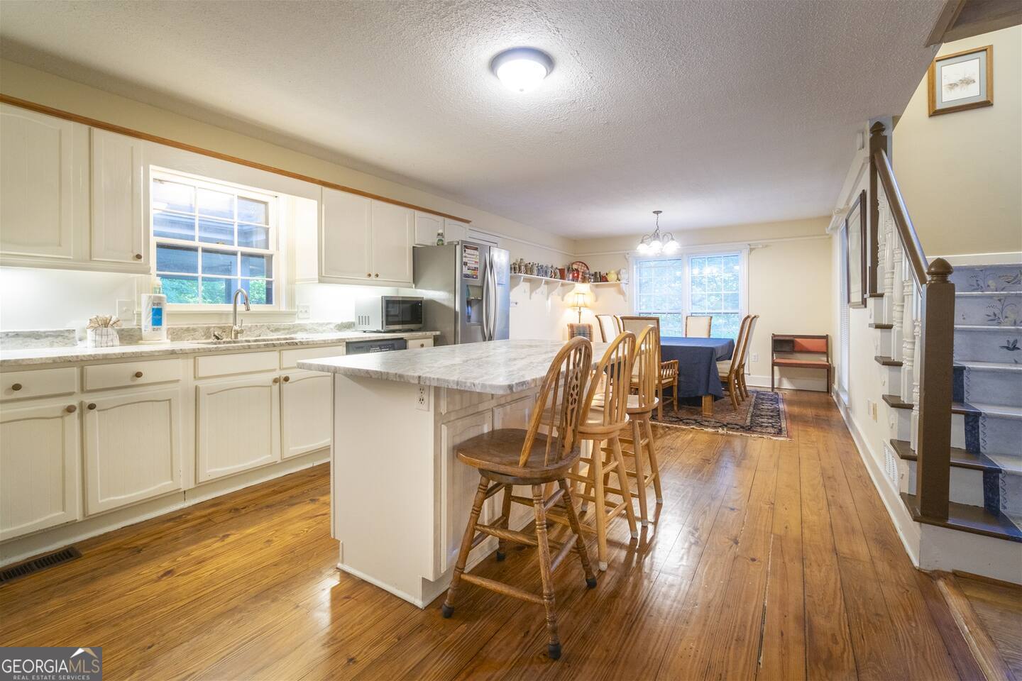 144 Fussen Strasse Helen, GA 30545 - Photo 12 of 38 a kitchen with stainless steel appliances a stove a sink dishwasher a refrigerator with white cabinets and wooden floor