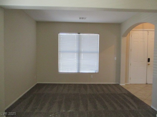 811 Wintersweet Road Henderson, NV 89015 - Photo 5 of 60 Spare room with arched walkways and dark colored carpet