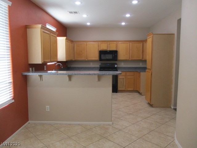 811 Wintersweet Road Henderson, NV 89015 - Photo 6 of 60 Kitchen with a kitchen bar, black appliances, a peninsula, light tile patterned flooring, and recessed lighting