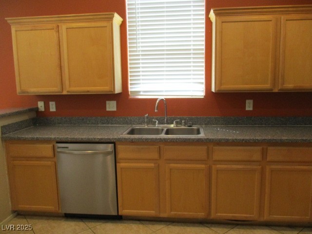 811 Wintersweet Road Henderson, NV 89015 - Photo 8 of 60 Kitchen featuring stainless steel dishwasher, dark countertops, light tile patterned floors, and brown cabinets