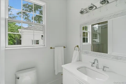 a bathroom with a sink toilet mirror and shower