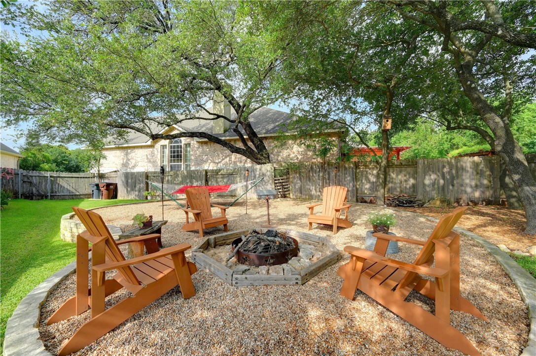 a view of a patio with couches table and chairs and a large tree