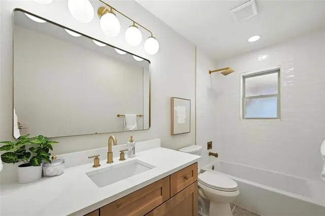 a bathroom with a sink toilet mirror and vanity