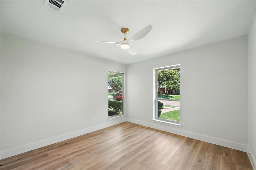 7620 La Risa Drive Dallas, TX 75248 - Photo 26 of 34 an empty room with wooden floor chandelier fan and windows