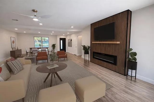 a living room with furniture a flat screen tv and kitchen view