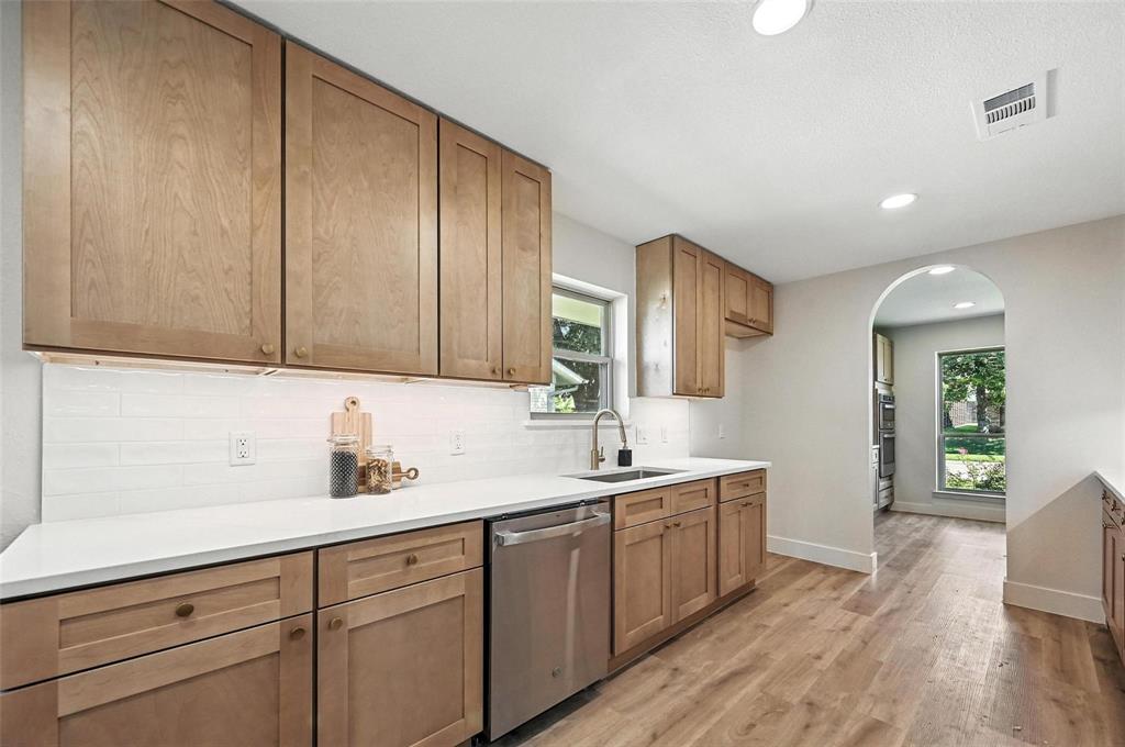 7620 La Risa Drive Dallas, TX 75248 - Photo 10 of 34 a kitchen with a sink cabinets and wooden floor