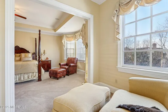 a bedroom with furniture and large windows