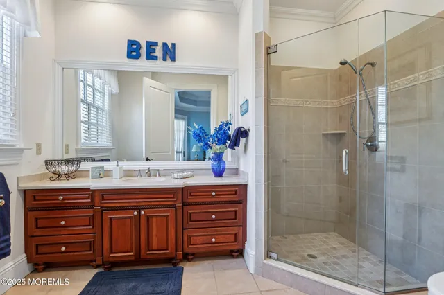 a bathroom with a granite countertop sink a mirror and a shower