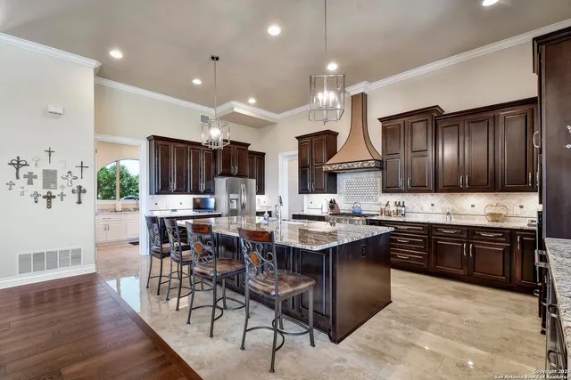 a large kitchen with granite countertop lots of counter space and stainless steel appliances