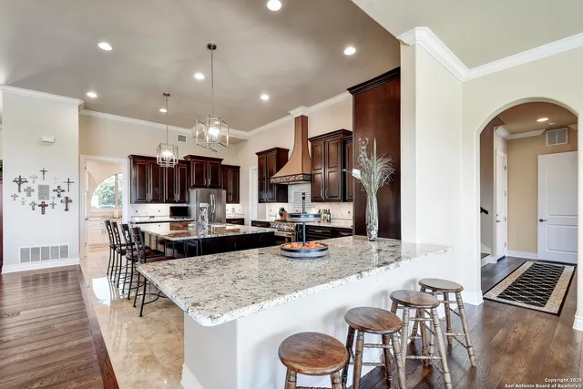 a kitchen with stainless steel appliances granite countertop a stove a sink and a refrigerator