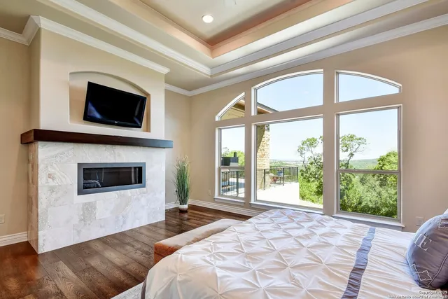 a bathroom with a granite countertop toilet a sink a mirror a window and vanity