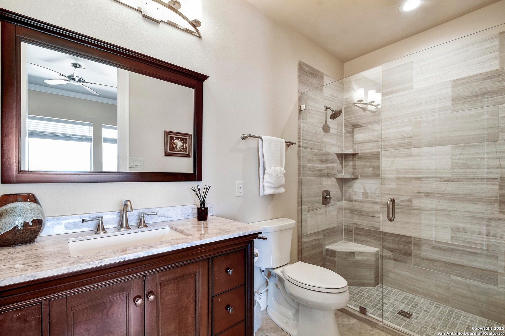 8 Braeburn Court Bulverde, TX 78163 - Photo 37 of 64 a bathroom with a granite countertop toilet a sink a mirror a window and vanity