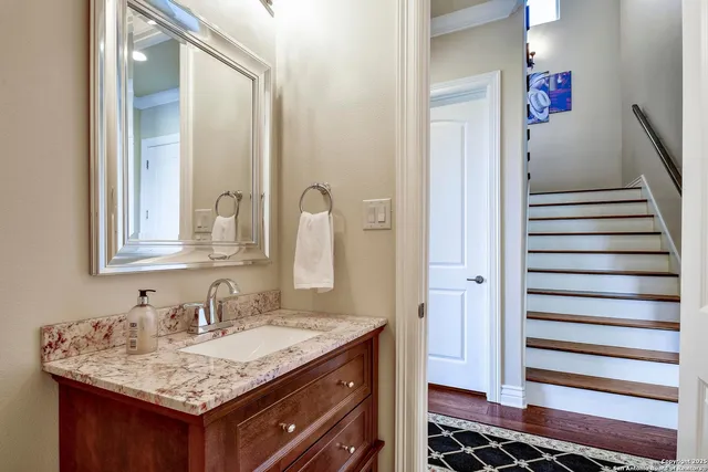 a bathroom with a granite countertop sink a toilet a mirror and shower curtain