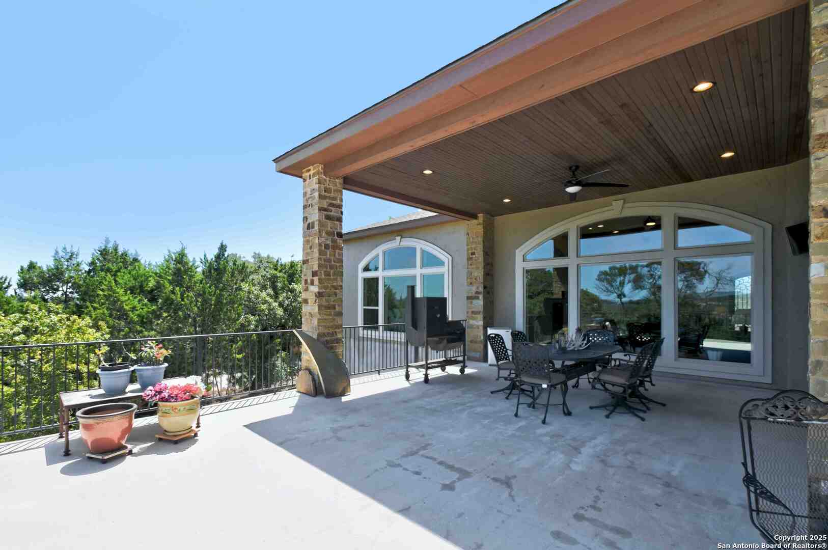 8 Braeburn Court Bulverde, TX 78163 - Photo 51 of 64 a view of a patio with table and chairs potted plants and floor to ceiling window