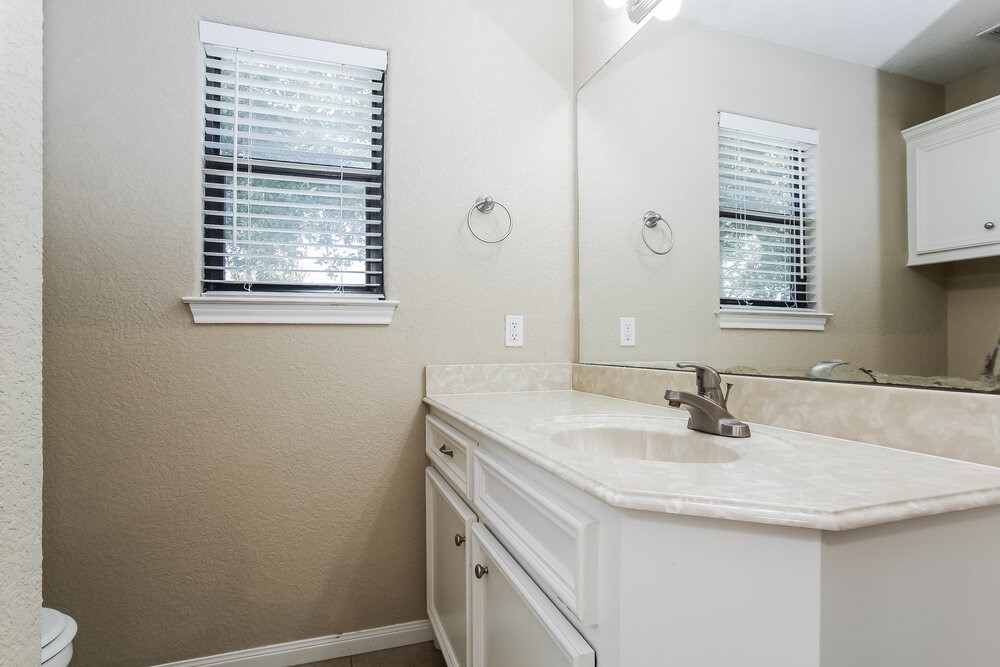 131 Golfview Court Conroe, TX 77356 - Photo 11 of 16 a bathroom with a sink a vanity and a window