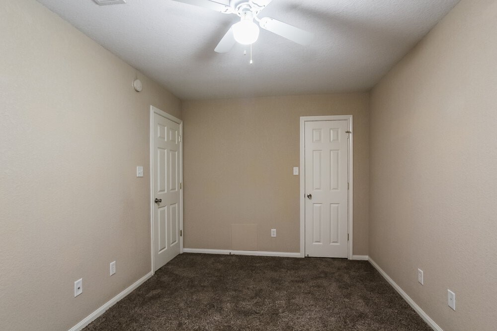 131 Golfview Court Conroe, TX 77356 - Photo 14 of 16 an empty room with a ceiling fan and window