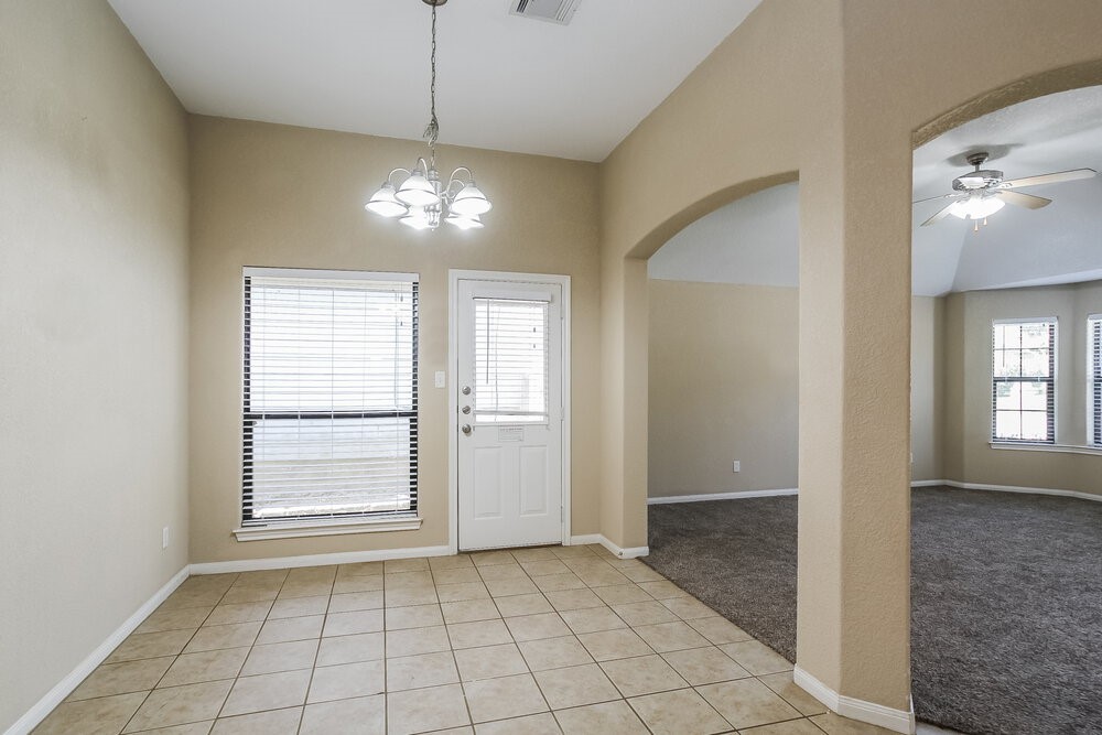 131 Golfview Court Conroe, TX 77356 - Photo 5 of 16 a view of an empty room with window and chandelier fan