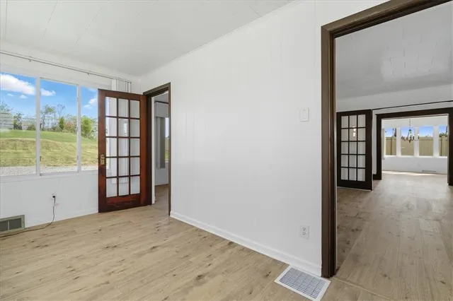 a view of a big room with wooden floor and windows