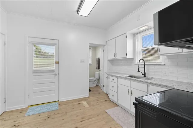 a kitchen with granite countertop a sink stove and cabinets