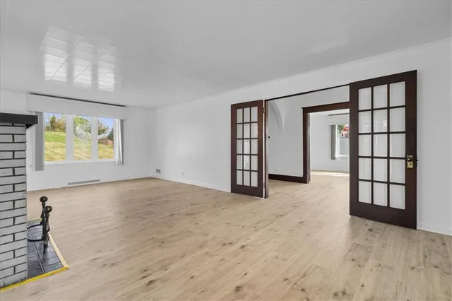 wooden floor in an empty room with a window