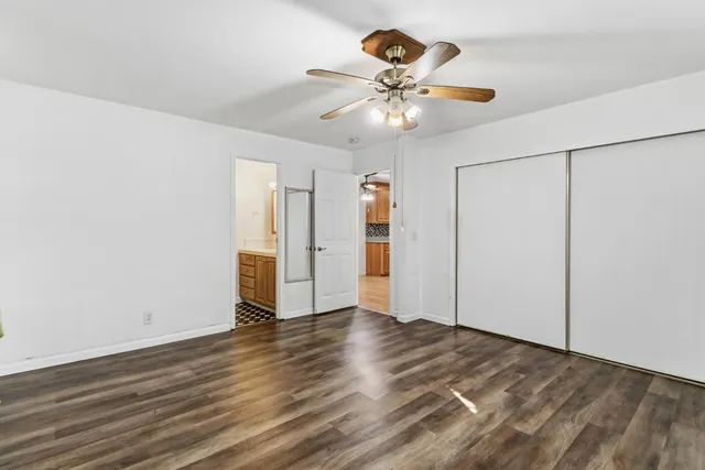 an empty room with a window and a ceiling fan