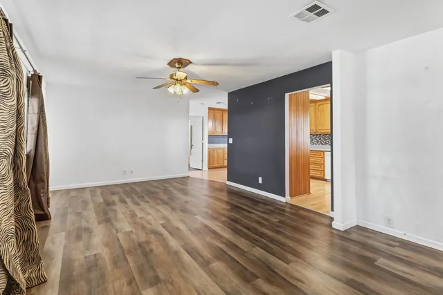 a view of empty room with window and wooden floor