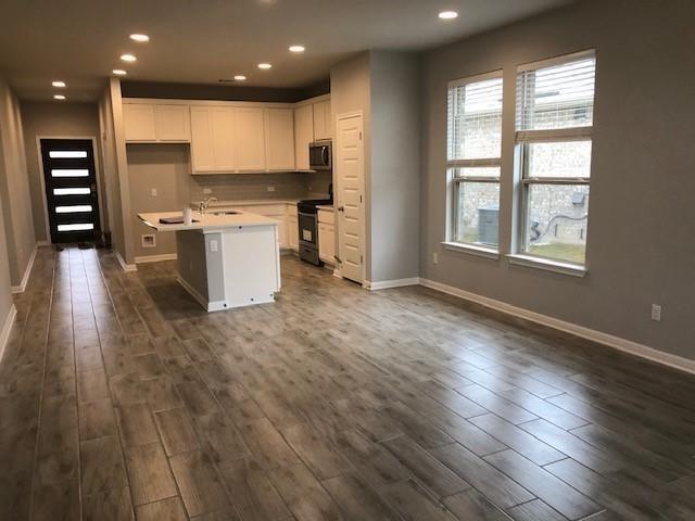 137 Peruvian Lane Georgetown, TX 78626 - Photo 3 of 12 an open kitchen with kitchen island wooden floors and center island