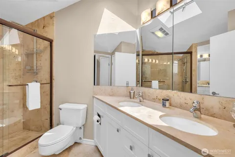 a bathroom with a sink a toilet a mirror and shower