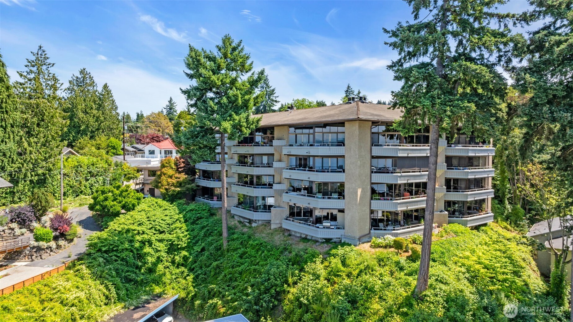 7019 47th Avenue Southwest, Unit 18 Seattle, WA 98136 - Photo 24 of 39 a view of a wooden bench with plants and large trees