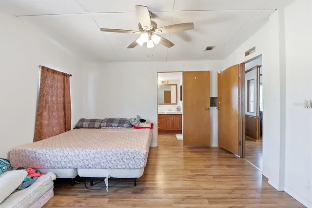 a bedroom with a bed and wooden floor