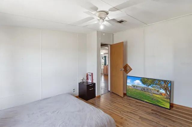 a view of a livingroom with wooden floor and a ceiling fan