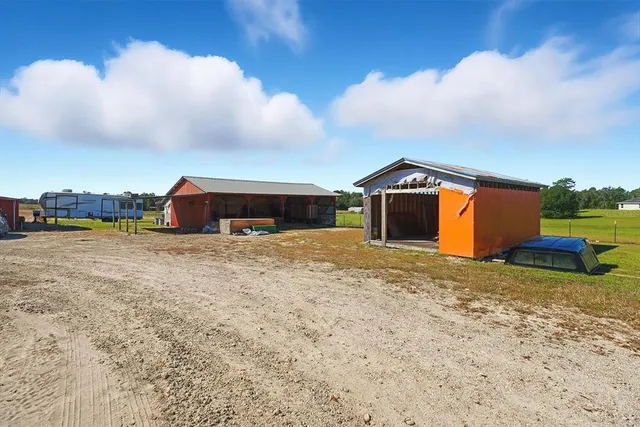 a view of a dry yard with wooden fence