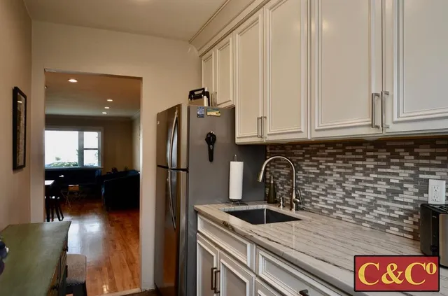 a kitchen with stainless steel appliances granite countertop a refrigerator and a sink