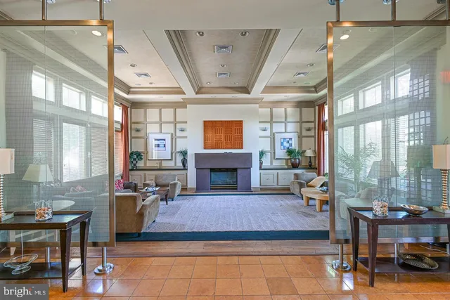 a living room with furniture a fireplace and potted plants