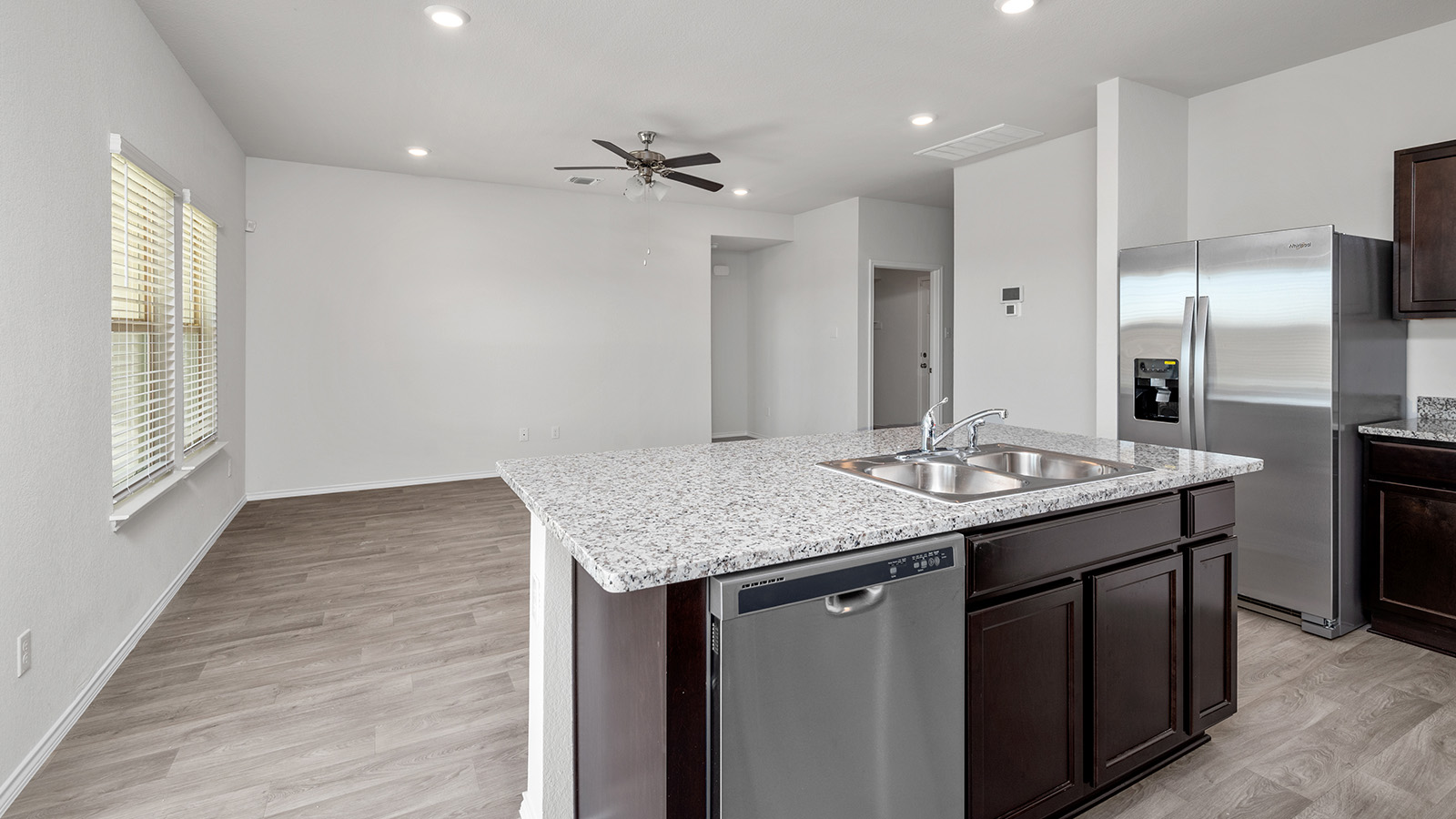 148 McNamara Court Jarrell, TX 76537 - Photo 3 of 22 Kitchen with dark wood finish cabinets, stainless steel appliances, a ceiling fan, a kitchen island with sink, and recessed lighting