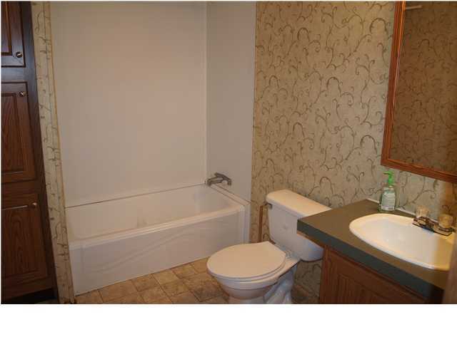 4493 Rainbird Rise Road Crestview, FL 32539 - Photo 14 of 27 a bathroom with a sink a toilet a mirror and bathtub