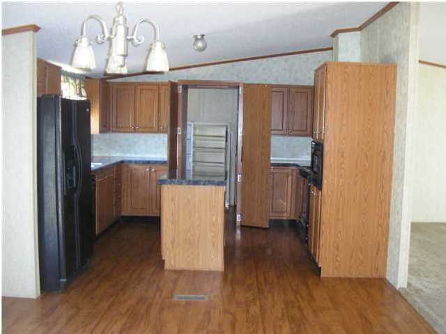 4493 Rainbird Rise Road Crestview, FL 32539 - Photo 5 of 27 a kitchen with stainless steel appliances a refrigerator and wooden floor