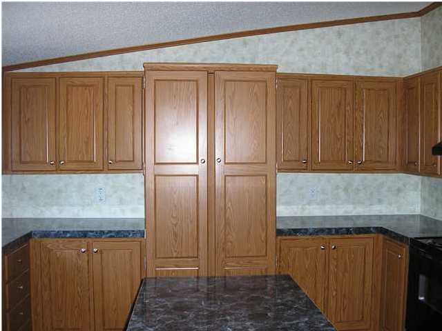 4493 Rainbird Rise Road Crestview, FL 32539 - Photo 6 of 27 a kitchen with stainless steel appliances granite countertop wooden cabinets and sink
