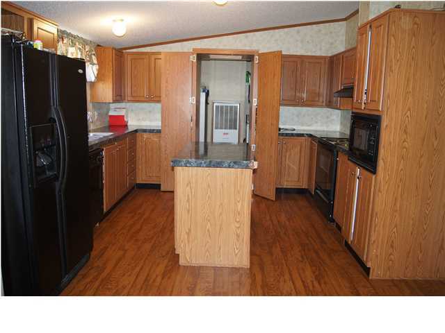 4493 Rainbird Rise Road Crestview, FL 32539 - Photo 8 of 27 a open kitchen with kitchen island wooden floors appliances and cabinets