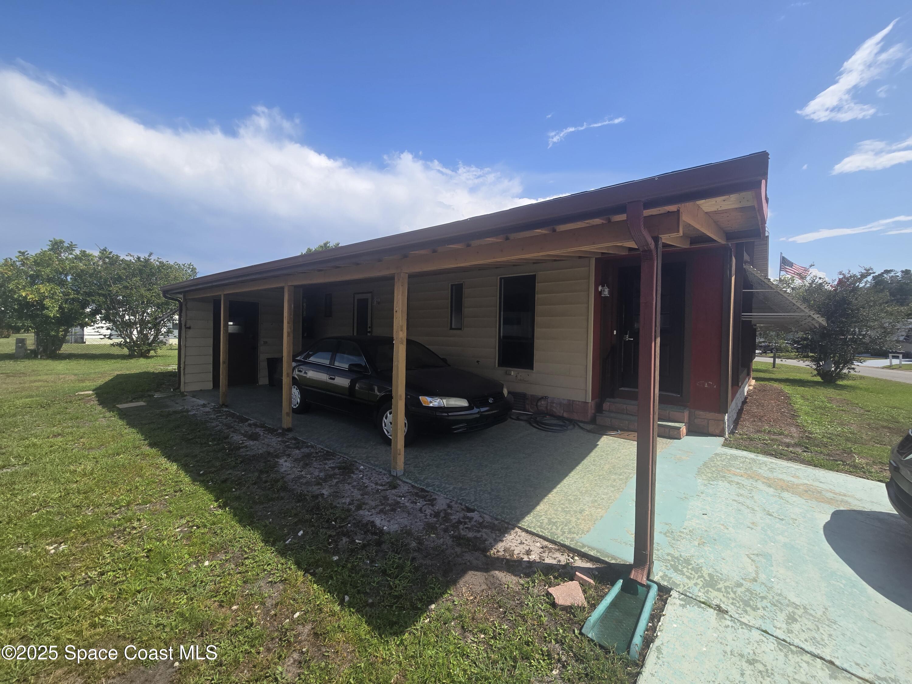 623 Marlin Circle Barefoot Bay, FL 32976 - Photo 2 of 20 a view of a house with backyard porch and a garden