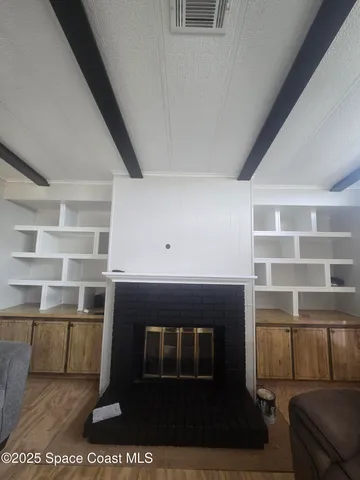 a living room with a fireplace and a book shelf