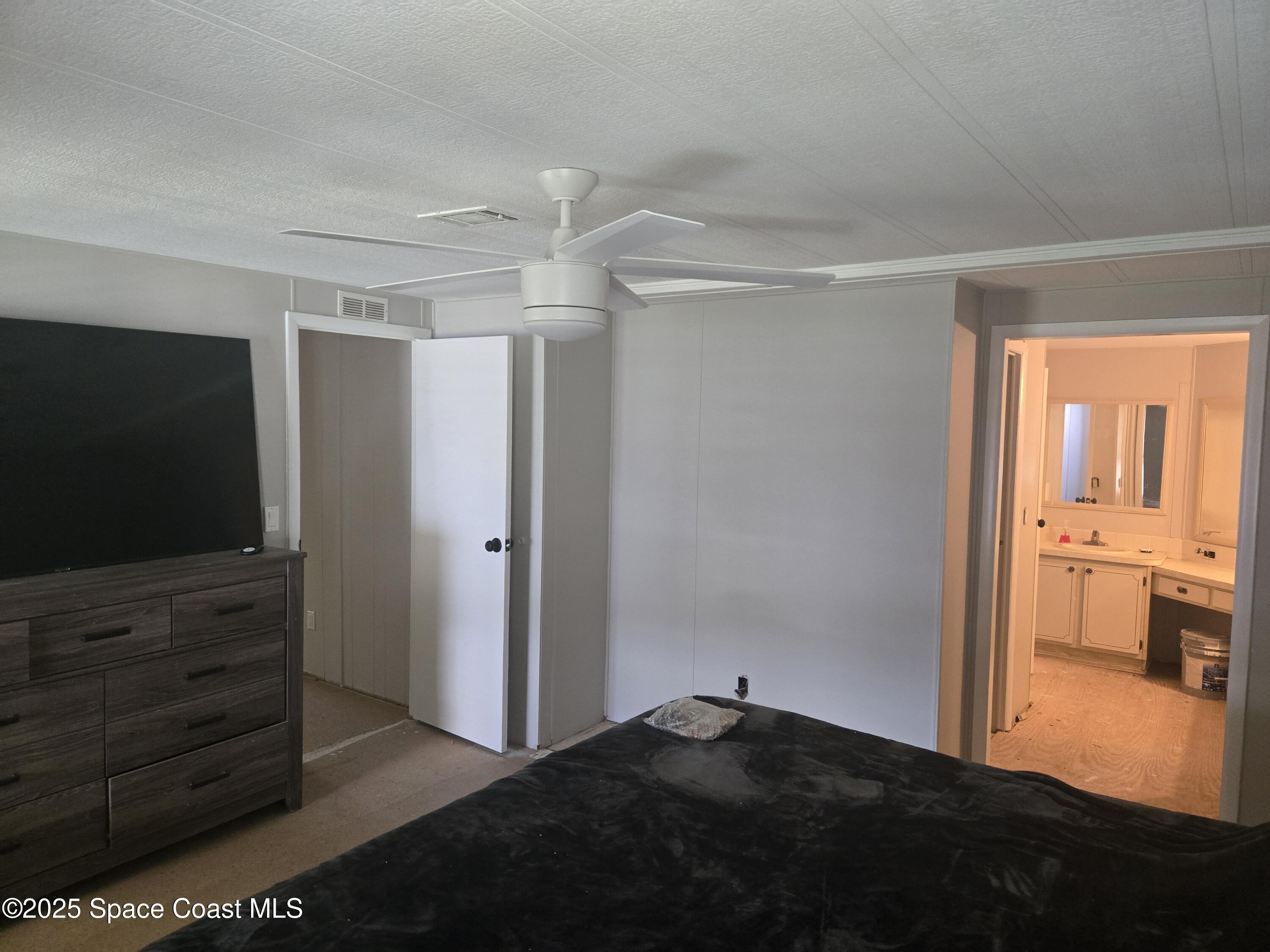 623 Marlin Circle Barefoot Bay, FL 32976 - Photo 8 of 20 a bedroom with a bed and a flat screen tv