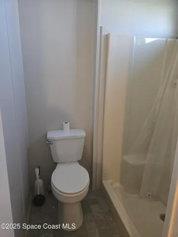 a bathroom with a toilet and a shower