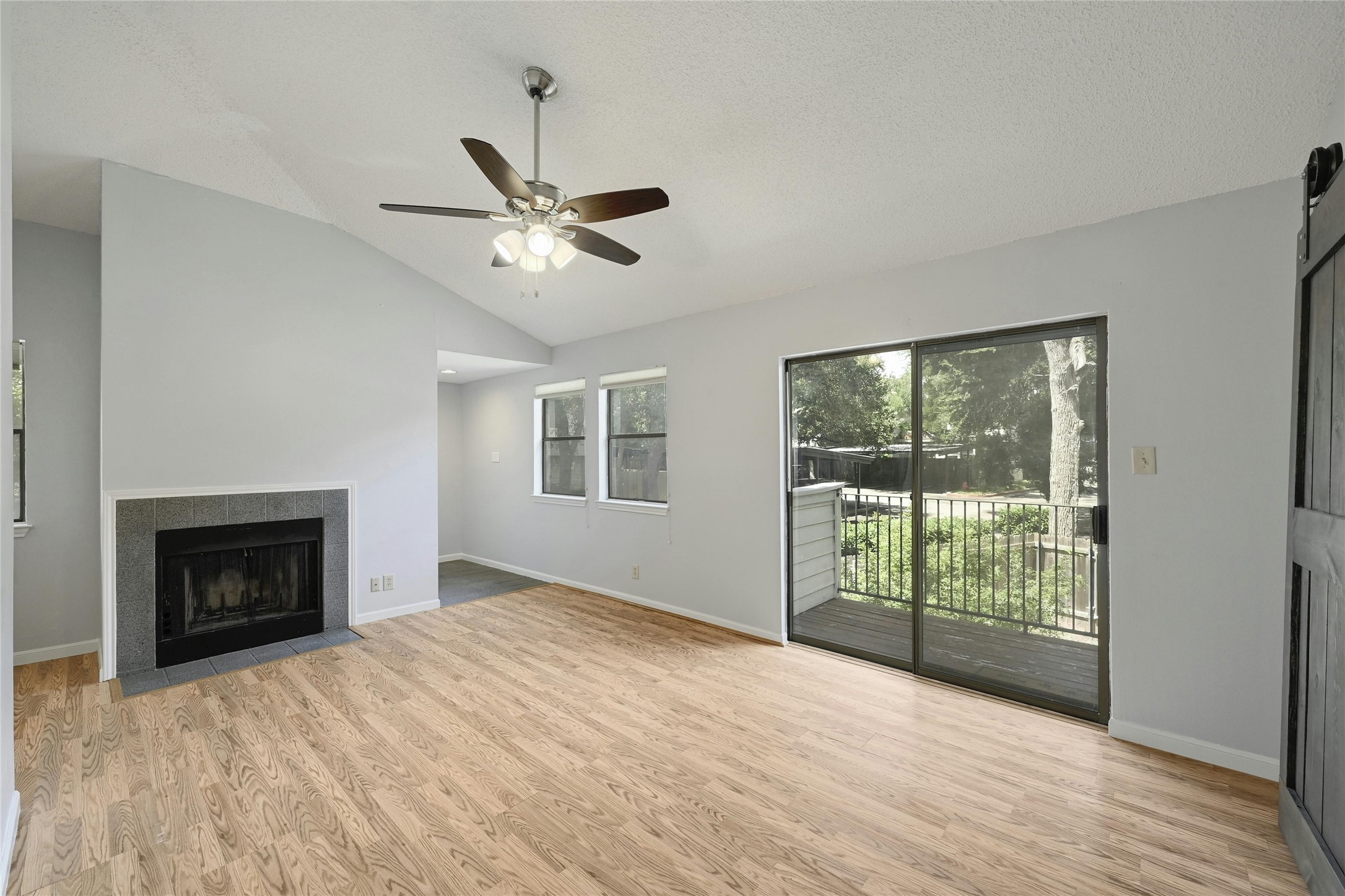9226 Jollyville Road, Unit 221 Austin, TX 78759 - Photo 4 of 20 Vast wooden flooring leads to a fireplace and sliding glass doors opening to the outdoors.