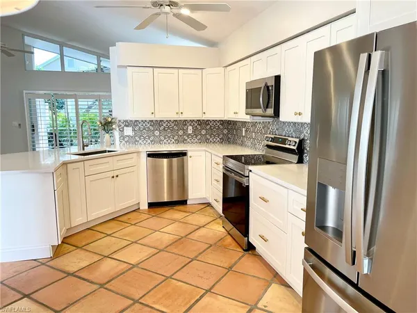 a kitchen with granite countertop a refrigerator stove and microwave
